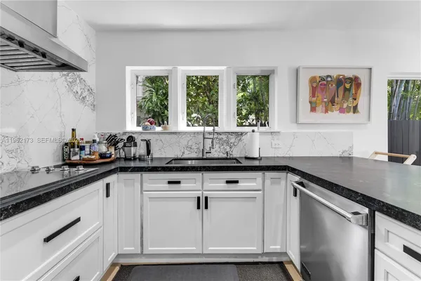 a kitchen with granite countertop white cabinets and white appliances