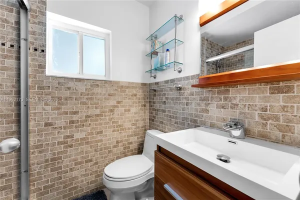 a bathroom with a sink a toilet and a mirror