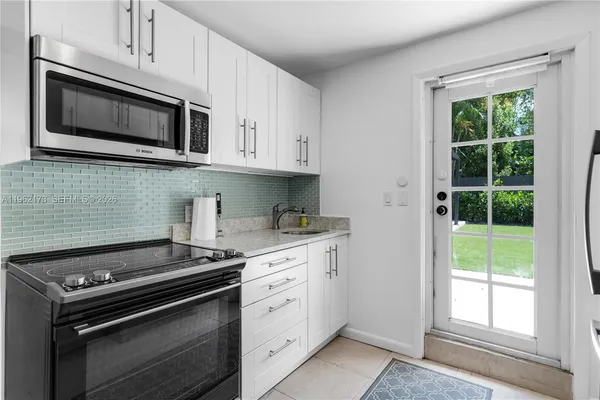 a kitchen with stainless steel appliances white cabinets and stove