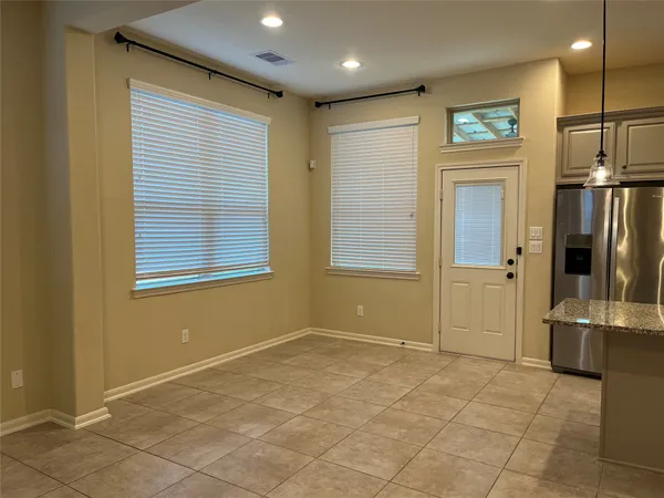 a view of a livingroom with an empty space and a kitchen