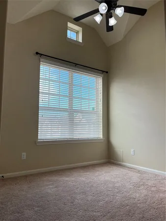 a view of an empty room with a chandelier fan