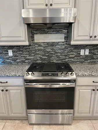 a stove top oven sitting inside of a kitchen