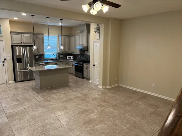 a kitchen with stainless steel appliances granite countertop a refrigerator and a sink