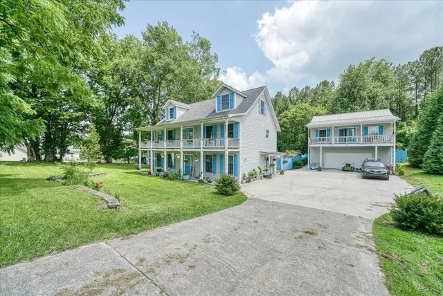 a front view of a house with a yard and trees
