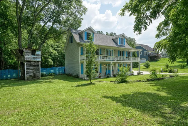 a view of a house with a yard and sitting area