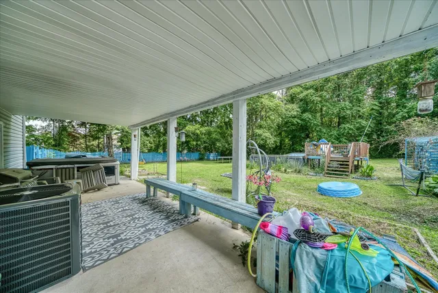 a view of a patio with table and chairs potted plants with wooden floor and fence