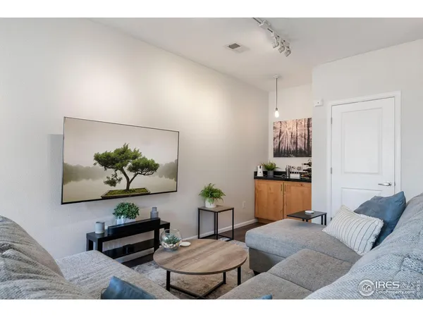 a living room with furniture and a painting on the wall