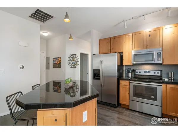 a kitchen with stainless steel appliances granite countertop a sink a stove and a refrigerator