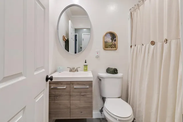 a bathroom with a toilet a sink and mirror