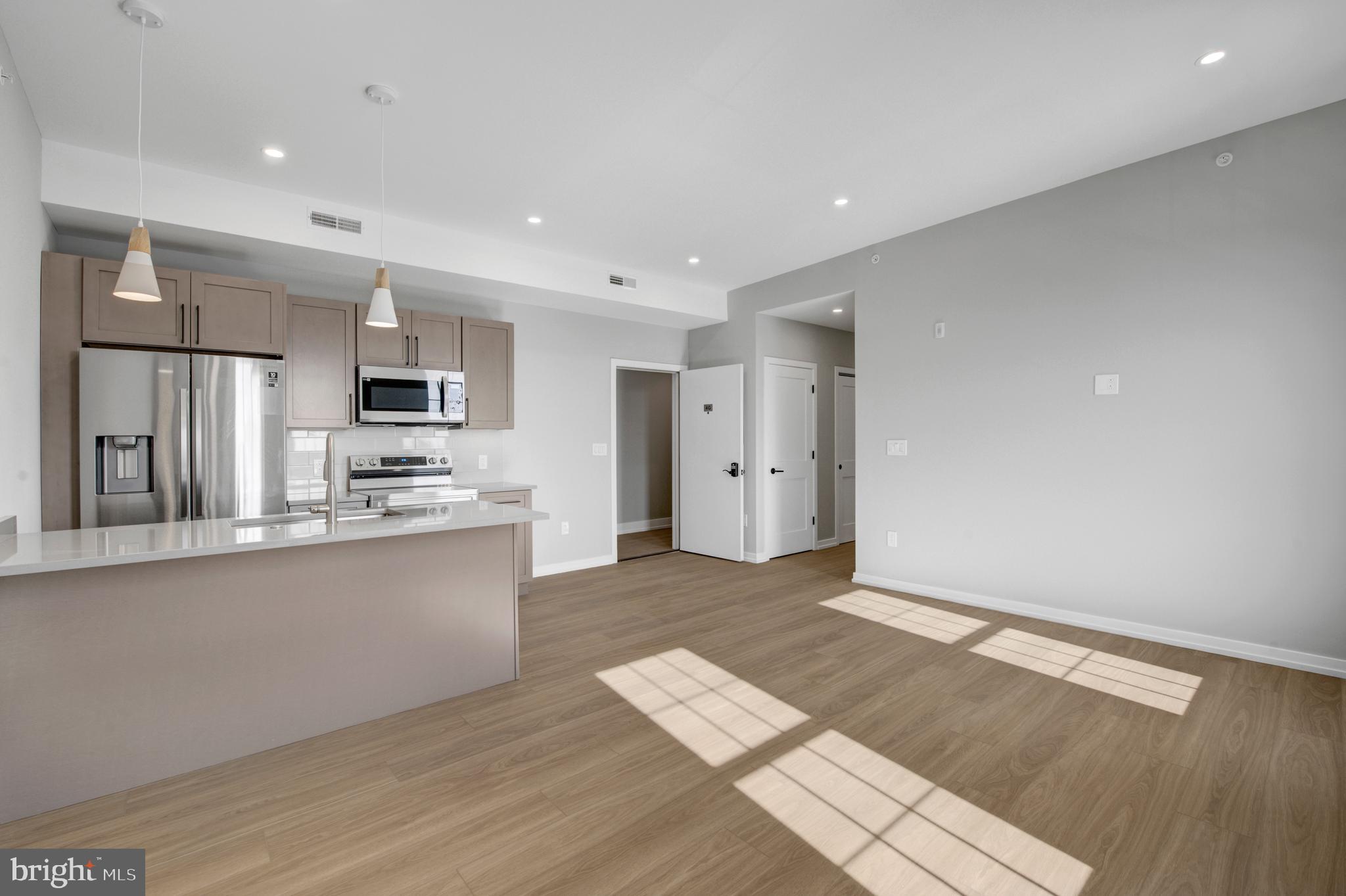 a large kitchen with stainless steel appliances granite countertop a refrigerator and a sink