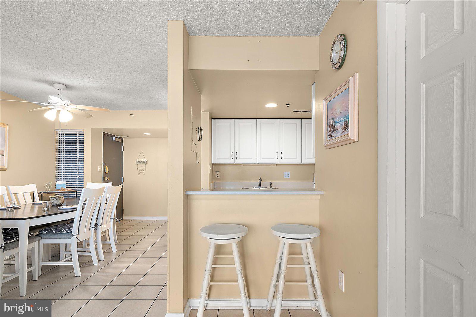 502 Island House Road Bethany Beach, DE 19930 - Photo 14 of 56 a kitchen with kitchen island cabinets and chairs in it