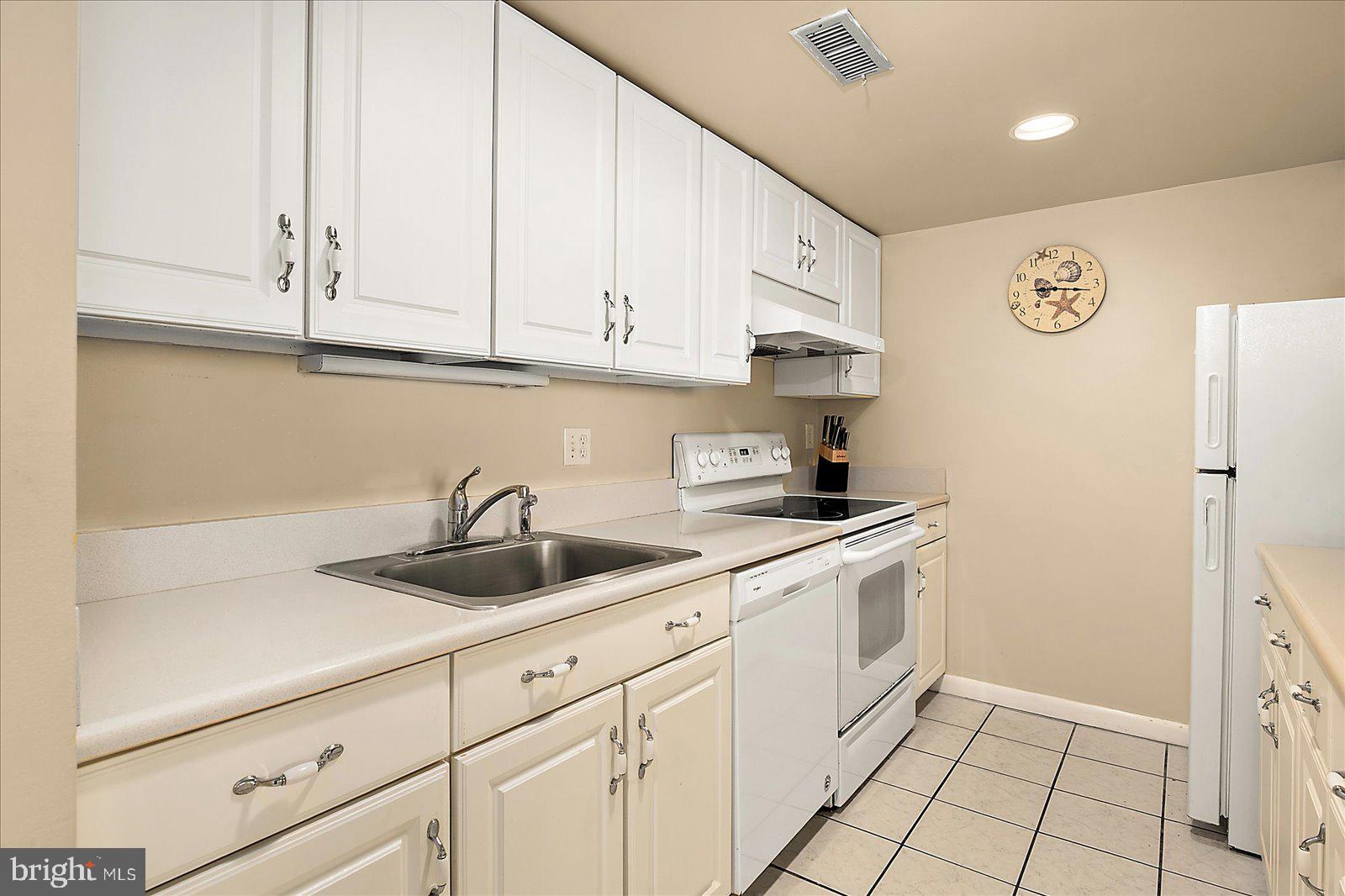 502 Island House Road Bethany Beach, DE 19930 - Photo 17 of 56 a kitchen with white cabinets and sink