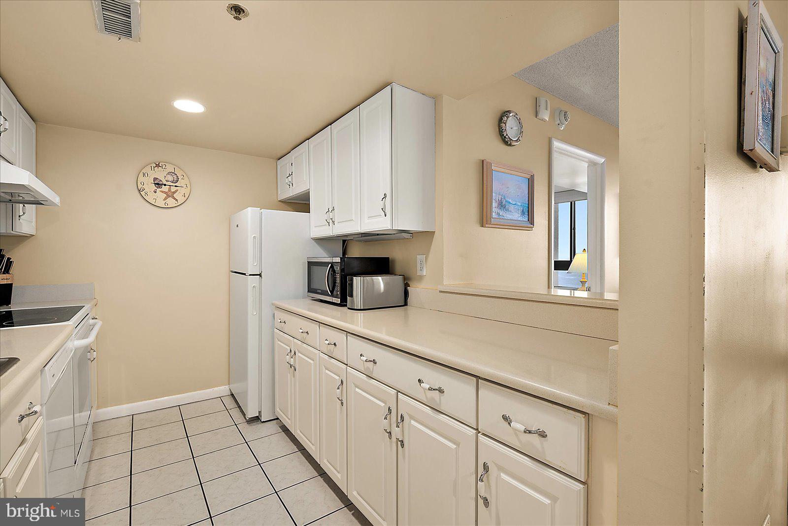 502 Island House Road Bethany Beach, DE 19930 - Photo 19 of 56 a kitchen with cabinets and a refrigerator