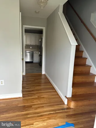 a view of a hallway with wooden floor and staircase
