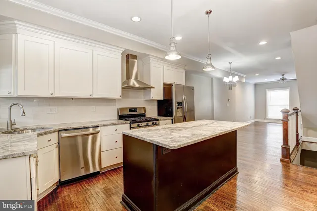 a large kitchen with kitchen island a sink a stove a dining table and chairs