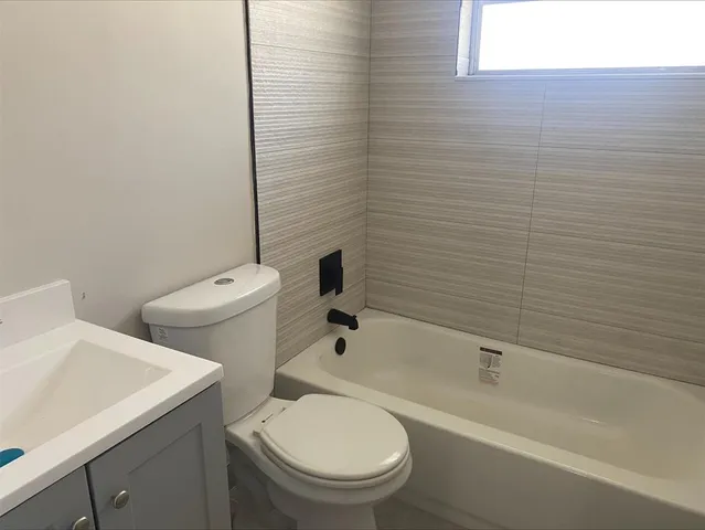 a white toilet sitting next to a bath tub