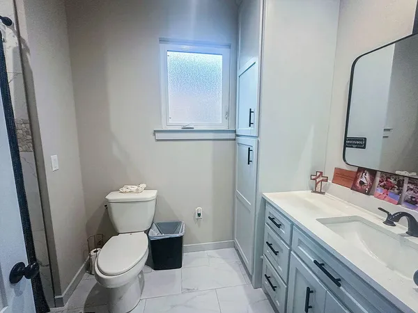 a bathroom with a toilet sink and mirror