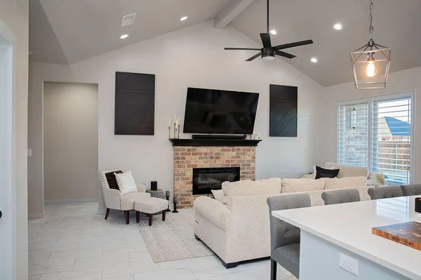 a living room with furniture a fireplace and a flat screen tv
