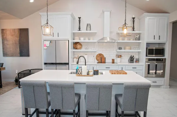 a kitchen with a sink a stove and chairs