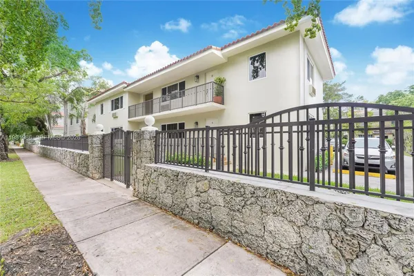 a view of a house with a small yard and wooden fence