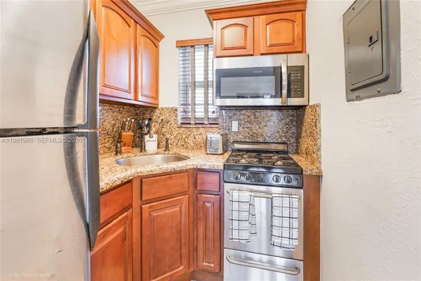 a kitchen with stainless steel appliances granite countertop a stove a sink and a refrigerator
