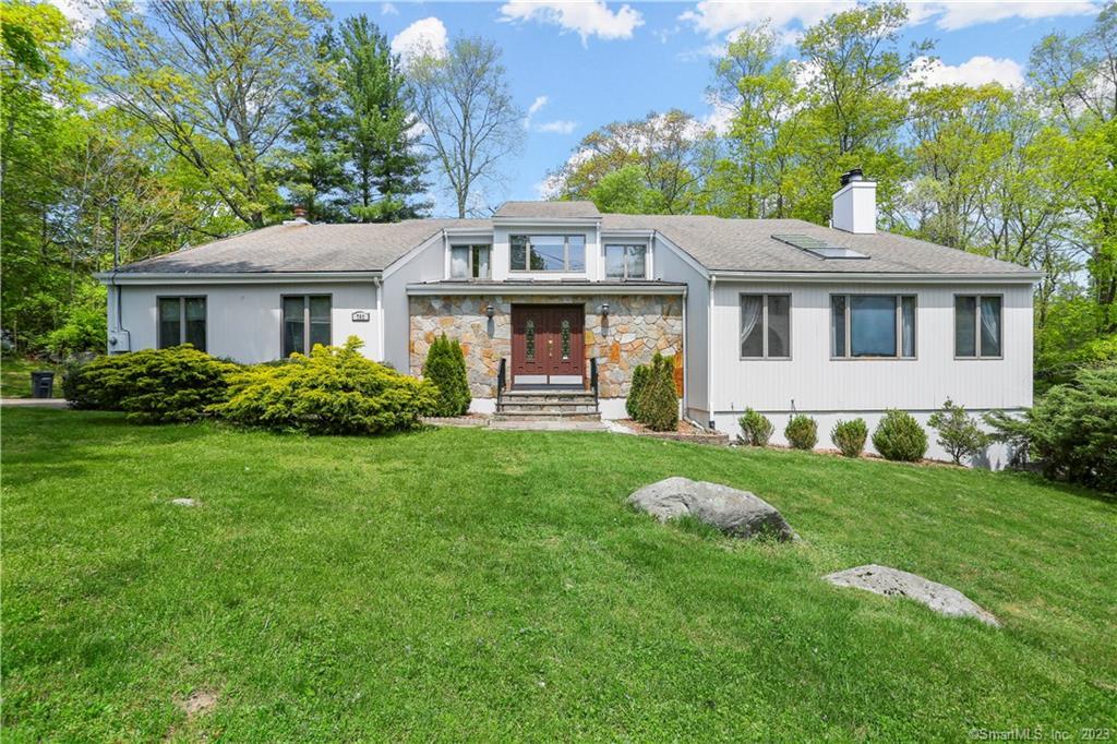 a front view of a house with a yard and green space
