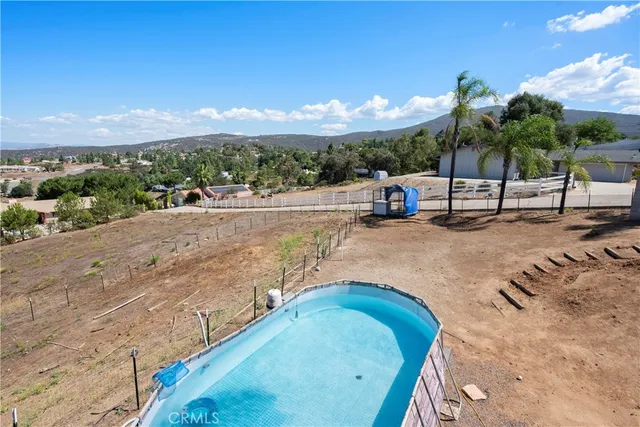 a view of a dry yard with wooden fence