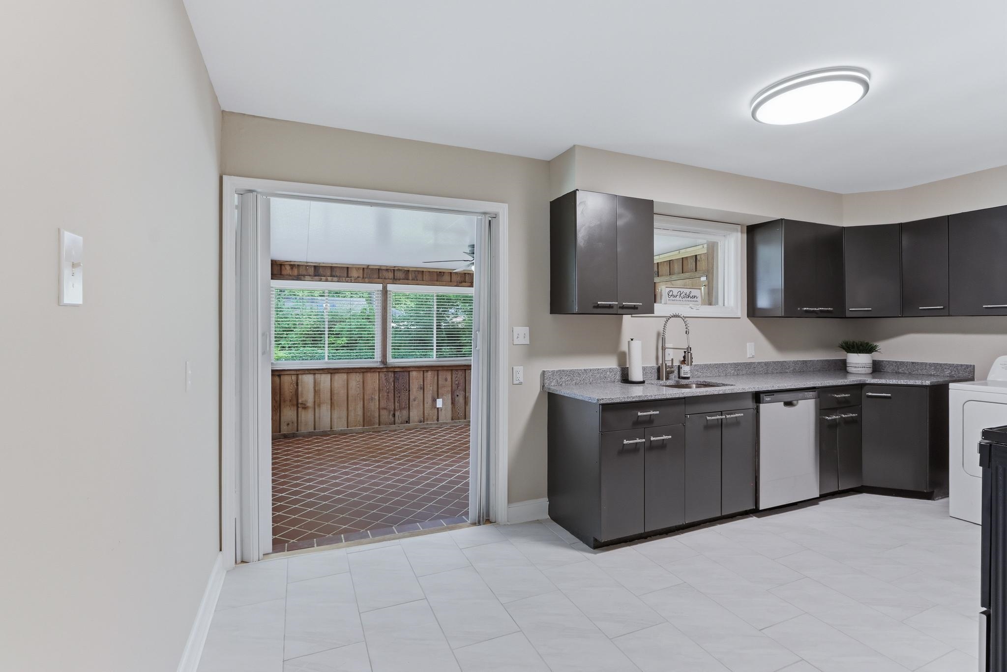 312 Fernway Road Memphis, TN 38117 - Photo 15 of 38 Kitchen featuring washer / dryer, dishwasher, light stone countertops, and dark cabinetry