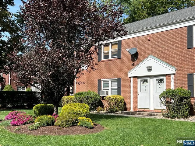 a front view of a house with a yard and potted plants