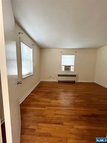 a view of a room with wooden floor and window