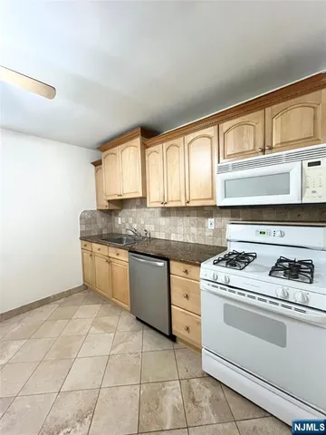 a kitchen with granite countertop a stove sink and cabinets