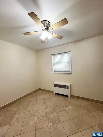a view of a livingroom with a ceiling fan and window