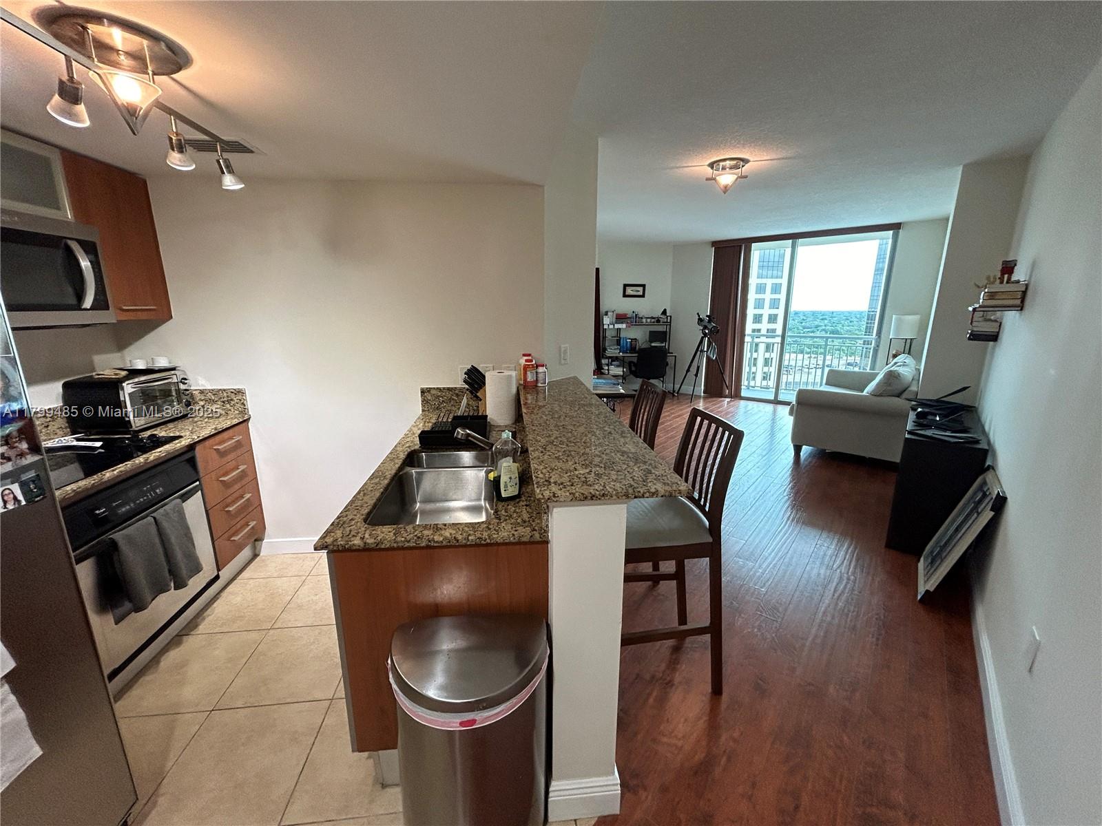 9066 Southwest 73rd Court, Unit 1504 Miami, FL 33156 - Photo 5 of 19 a kitchen with sink a microwave a stove and furniture