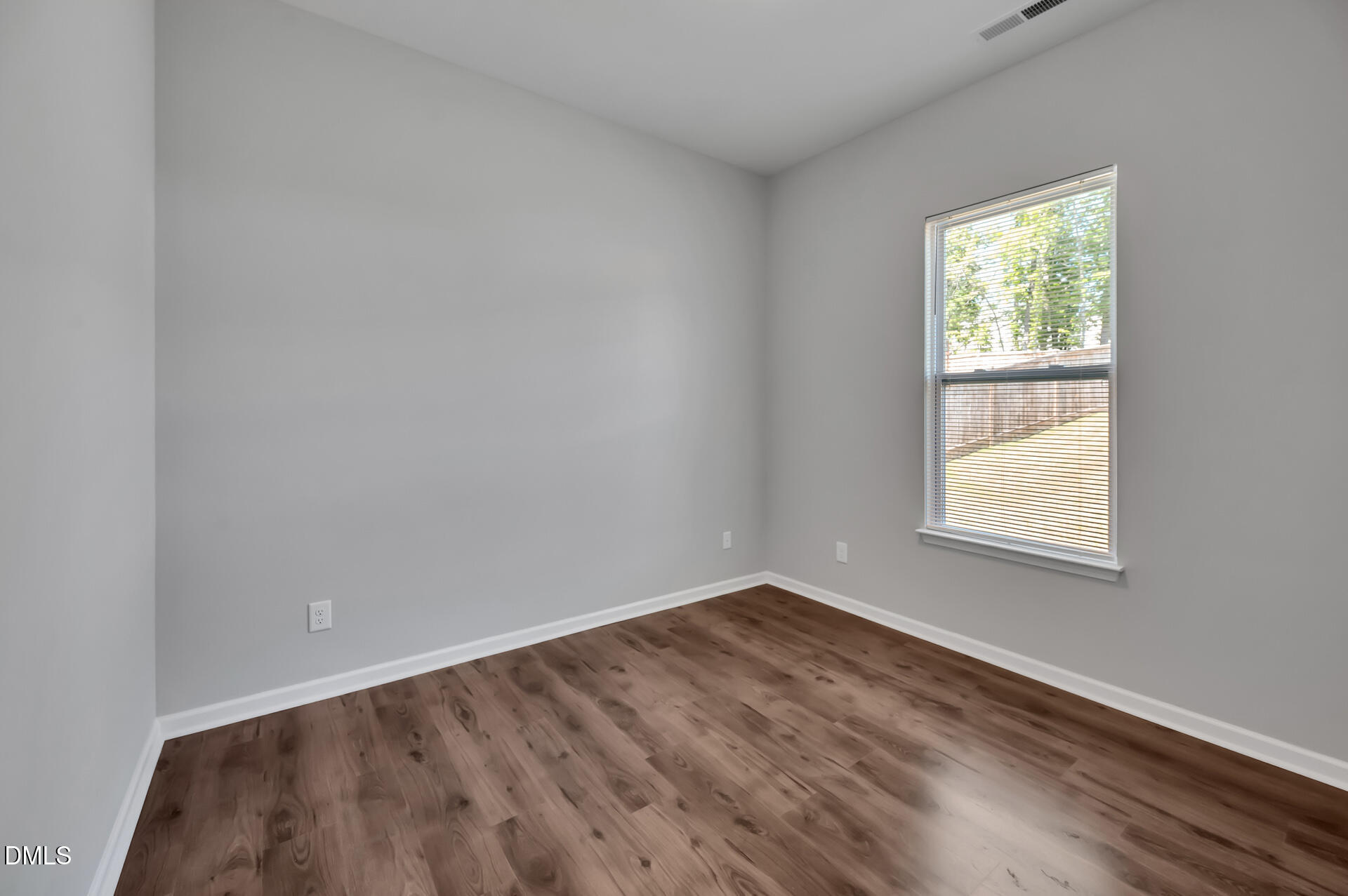 5406 Ripplebrook Drive Durham, NC 27712 - Photo 18 of 37 a view of an empty room with wooden floor and a window