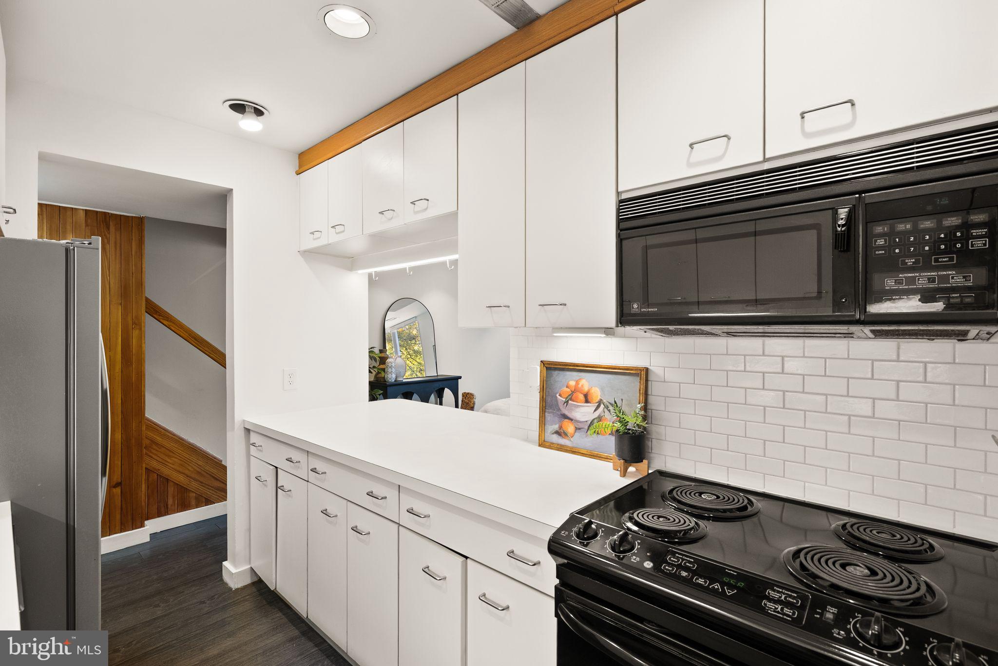 11577 Maple Ridge Road Reston, VA 20190 - Photo 11 of 48 a kitchen with stainless steel appliances granite countertop a stove and a microwave