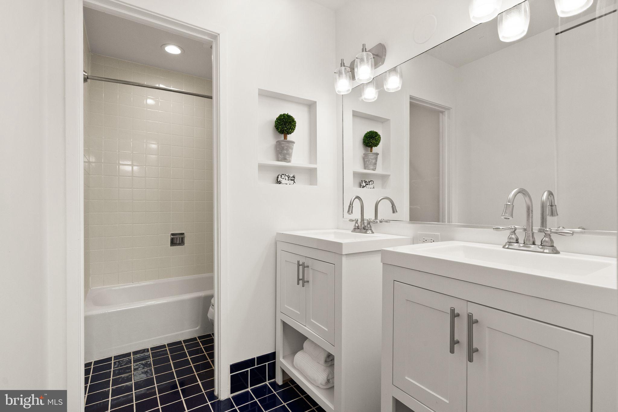 11577 Maple Ridge Road Reston, VA 20190 - Photo 40 of 48 a bathroom with a sink a large mirror and shower