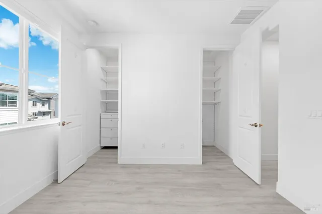 a view of a hallway with wooden floor and closet