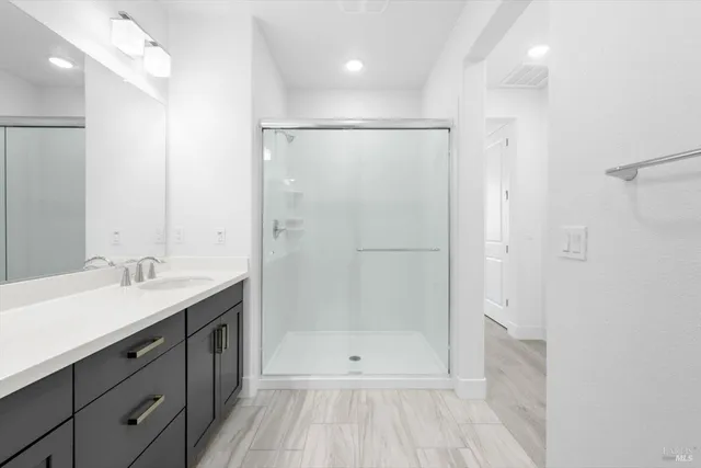 a bathroom with a shower sink and mirror