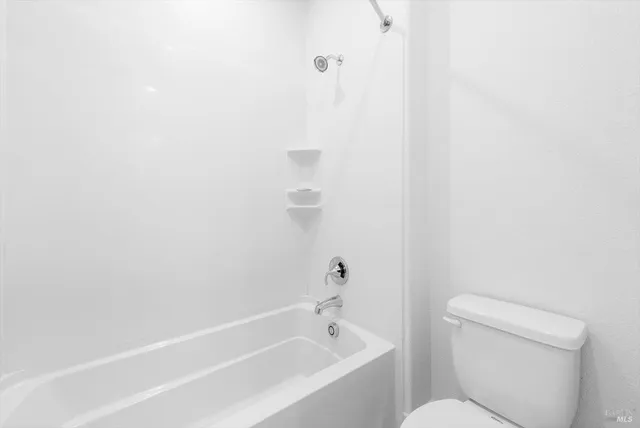 a white bath tub sitting next to a white toilet