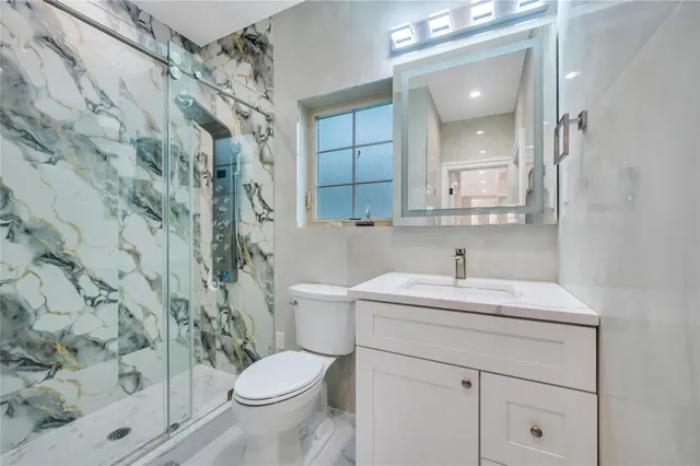 a bathroom with a sink a toilet and a mirror