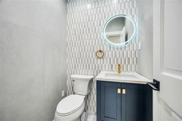 a bathroom with a sink a toilet and a mirror