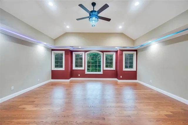 a view of an empty room with window and wooden floor