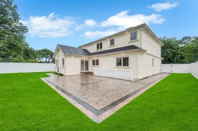 a view of a white house with a big yard and large trees