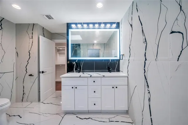 a bathroom with a double vanity sink mirror and shower