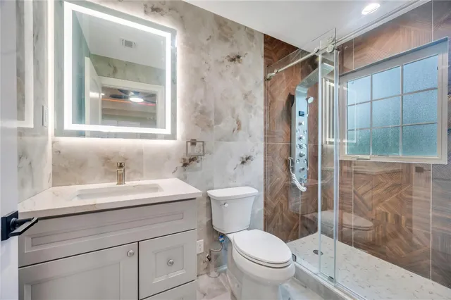 a bathroom with a sink a toilet and shower