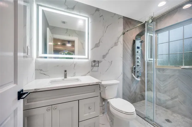 a bathroom with a toilet sink vanity and mirror