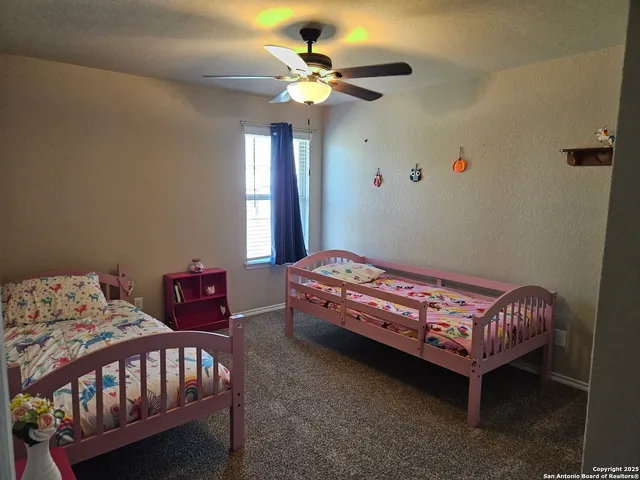 a bedroom with a bed a chandelier and a dresser