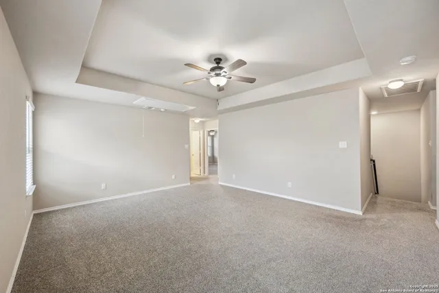 an empty room with a ceiling fan and a fan