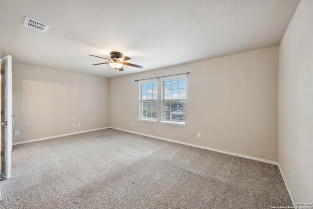 a view of a room with a window and a ceiling fan