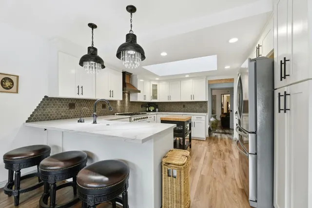 a kitchen with a dining table chairs sink and stove